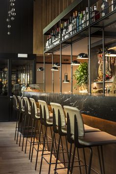 the bar is lined with chairs and bottles