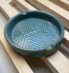 a blue bowl sitting on top of wooden slats