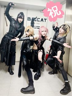 four people dressed in black posing for the camera