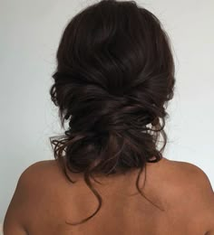 the back of a woman's head, with her hair in a low bun