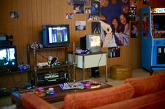 a living room filled with lots of furniture and pictures on the wall next to a flat screen tv