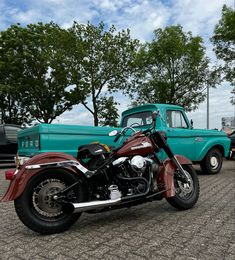 a red and black motorcycle parked next to a blue truck