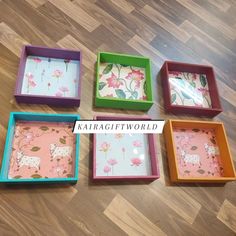 four square trays with flowers and animals on them are sitting on the floor next to each other