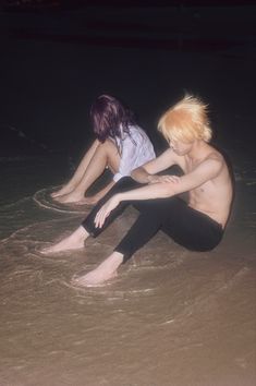 two people sitting in the water at night