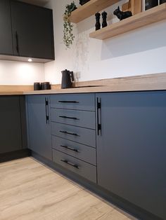 an empty kitchen with blue cabinets and wood flooring on the counter top, is pictured