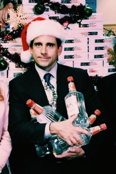 a man in a santa hat holding two bottles