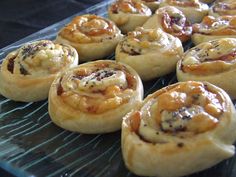 many small pastries are on a glass plate