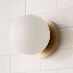 an overhead view of a light fixture on a white tile wall with gold trimming