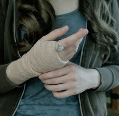 a woman with bandages on her arm holding something in her hand