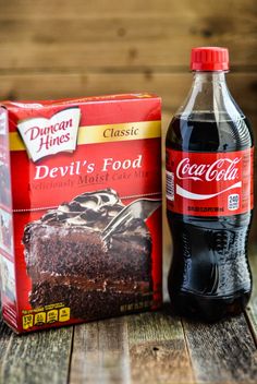 a box of devil's food next to a bottle of coca - cola on a wooden table