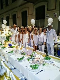 a group of people standing around a long table