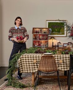 a woman standing next to a table covered in christmas decorations