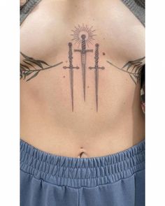 a woman's lower back with two swords and the sun behind her tattoo design