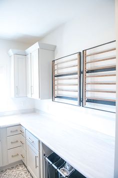 an empty kitchen with white cabinets and drawers