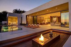 an outdoor living area with fire pit and lounge chairs