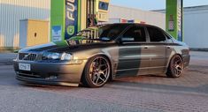 a silver car parked in front of a gas station