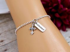 "This elegant and simple Cross Blessed Bracelet features a sterling silver Cross Charm and a sterling silver Blessed Charm on a sterling silver chain finished with a lobster clasp closure. Bracelet is solid sterling silver, fully adjustable and comes with the option to add a personalized printed gift tag. A beautiful design of scroll work enhances this classic cross. BRACELET DETAILS: * Strong sterling silver cable chain finished with a secure lobster clasp closure * Bracelet is adjustable with Inspirational Sterling Silver Nickel-free Bracelets, Inspirational Hypoallergenic Silver Bracelets, Personalized Silver Rosary Bracelet For Mother's Day, Spiritual Silver Charm Bracelet For Mother's Day, Inspirational Silver Charm Bracelet For Mother's Day, Mother's Day Silver Spiritual Charm Bracelet, Mother's Day Spiritual Silver Charm Bracelet, Engraved Silver Rosary Bracelet As Gift, Blessed Bracelet