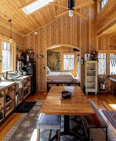 a kitchen and living room with wood paneling on the walls, windows, and ceiling