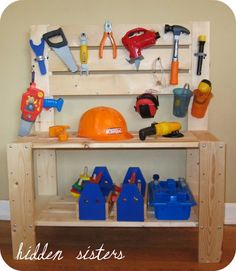 a wooden work bench with tools and construction equipment on it's shelf, in front of a wall