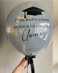 someone is holding up a balloon that says congratulations on your graduation