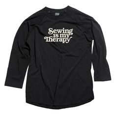 a black shirt with the words sewing is my therapy printed in white on it's chest