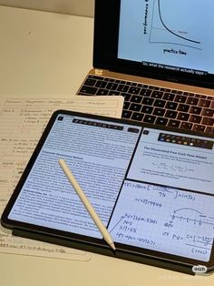 an open laptop computer sitting on top of a desk next to a calculator