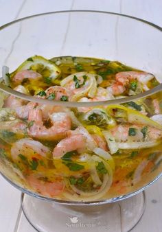 a glass bowl filled with shrimp and onions