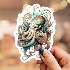 an octopus sticker is held up in front of a blurry background