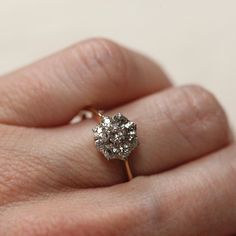 a woman's hand with a diamond ring on top of her finger, showing the center stone