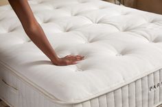 a person reaching for the bottom of a mattress