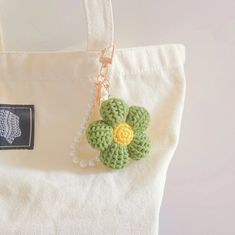 a crocheted flower is attached to a white bag with a tag on it