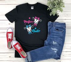 "* All shirts are unisex. * Product measurements may vary by up to 2 inches. * All Designs are originally made by myself or my team.  Gender Reveal shirt with the quote \"Heifer Or Bull\" is a fun gift for men and women!  To see more designs of your topic Gender Reveal you can search & find them in the store:   https://www.etsy.com/shop/Retailorie  You find there also an announcement if the shipping & production times change :) heifer shirt,bull shirt,funny gender reveal,gender reveal shirt,baby shower shirts,baby announcement,baby reveal shirts,gender reveal party,pregnancy shirt,pregnancy reveal,gender reveal gift,she or he,team boy or girl," Casual Tops With Funny Print For Gender Reveal, Casual T-shirt With Custom Print For Gender Reveal, Casual Tops With Custom Print For Gender Reveal, Casual Blue Shirt For Gender Reveal, Casual Cotton T-shirt For Gender Reveal, Black Short Sleeve Tops For Gender Reveal, Casual Short Sleeve Shirt For Gender Reveal, Casual Cotton Tops For Gender Reveal, Baby Shower Shirts For Family