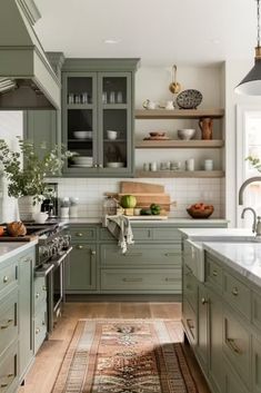 a kitchen filled with lots of green cabinets and counter top space next to an oven