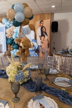 a table set up for a baby's first birthday party with balloons and decorations