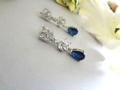 Matching Hair Accessories: https://www.etsy.com/listing/1285364716 https://www.etsy.com/listing/1312796838 https://www.etsy.com/listing/880678156 https://www.etsy.com/listing/1304601524 Matching Bracelet: https://www.etsy.com/listing/1313884115 These Handmade, crystal earrings are comprised of AAA Cubic Zirconia Marquise Leaf Cluster Long Ear Stud Posts in white gold plated frame and Sapphire Pear Cut Teardrop. Pure Elegance. The earrings measure .25" in width and 1.25" in length from top of ear post to tip of earring.  Free USA First Class Standard Shipping! Priority/Express Mail Upgrade Services are available and the customers responsibility. This will be shipped in a gift box or organza bag and in a bubble envelope.  Gift Wrapping Services Are Available At Checkout.  SHIPPING INSURANCE Blue Teardrop Earrings For Wedding, Elegant Blue Bridal Earrings For Wedding, Bride Something Blue, Drop Bridal Earrings, Blue Wedding Jewelry, Envelope Gift, Something Blue Wedding, Bridal Earrings Drop, Earrings Teardrop