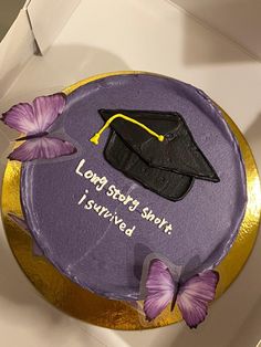 a purple cake decorated with a graduation cap and butterflies