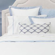 a bed with blue and white pillows on it