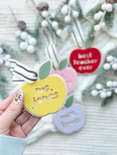 a person holding an apple shaped card with the words mrs jones on it and two hearts