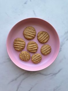 six peanut butter cookies on a pink plate