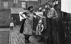 an old black and white photo of three people holding hands with a small child in the foreground