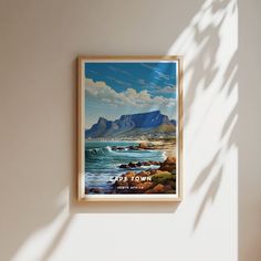 a painting hanging on the wall next to a chair and table in front of a window