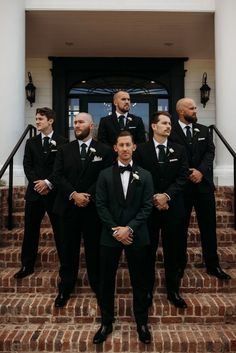 a group of men in tuxedos standing on steps