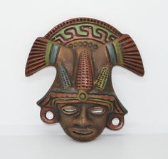 an african mask is hanging on the wall