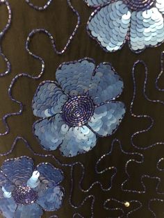 This is a beaded silk top. The random design is done with iridescent cobalt blue bugle beads. The large flowers are made up of the same beads with the petals done in sequins. There are also round silver beads interspersed front and back. My favorite part of this top is the scalloped effect the flowers give to the sleeves and hemline. A unique touch. No size tag, fits like a M/L with no stretch. Check measurements carefully. Lined with rayon. Length 26 inches Underarm to underarm 40 inches Waist Spring Blue Beaded Tops, Vintage Embellished Festive Tops, Blue Bohemian Beaded Top, Party Sequin Fabric With Floral Embroidery In Blue, Blue Embellished Sequin Fabric For Festive Occasions, Luxury Beaded Black Tops, Vintage Beaded Fitted Tops, Blue Beaded Fitted Sequin Fabric, Fitted Blue Beaded Sequin Fabric