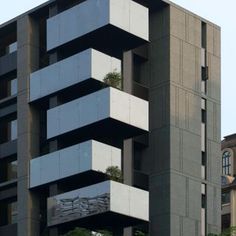 an apartment building with balconies and plants growing on the balconys in front of it