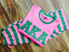 two pink and green striped shorts sitting on top of a wooden floor next to each other