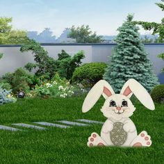 a white rabbit sitting on top of a lush green field