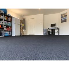 a room with carpet, shelves and a desk in it