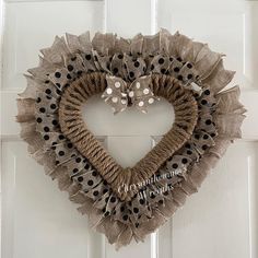 a heart shaped burlock hanging on a door with polka dots and bow ties