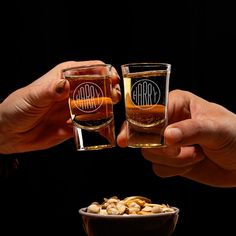 two people toasting glasses with peanuts in front of them